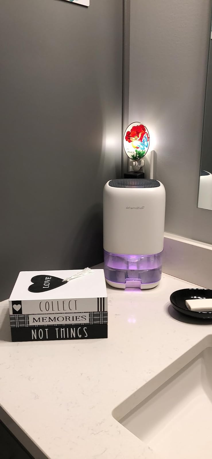 Small white dehumidifier with purple night-light glowing