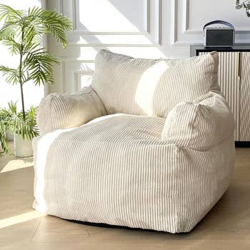 Oversized bean bag chair in a room, next to a small table with a compact stereo system