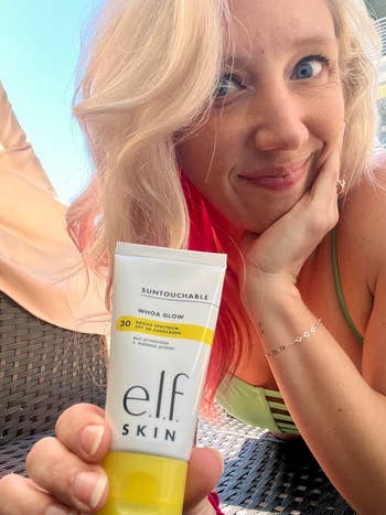A idiosyncratic smiling and holding a conduit of e.l.f. Skin's