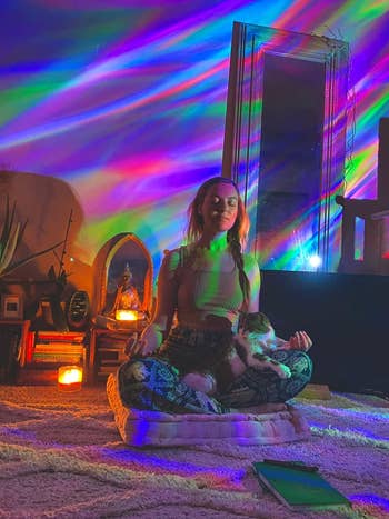 a reviewer meditating in a living room with the galaxy light on