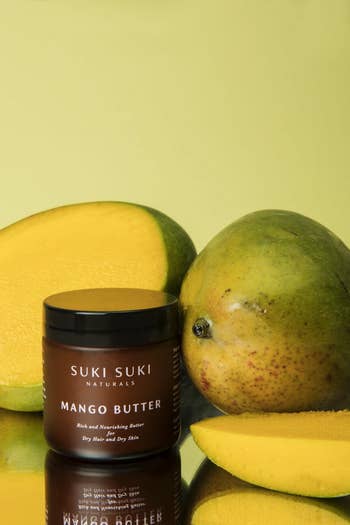 The jar of mango butter in front of sliced up mangoes