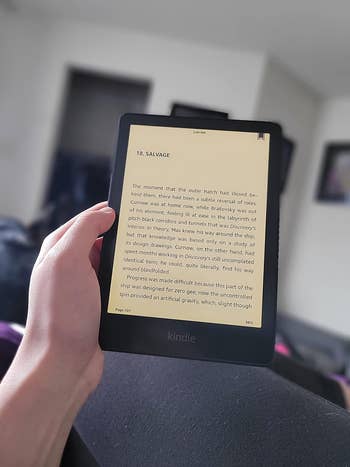 reviewer holding the kindle with the warm light on