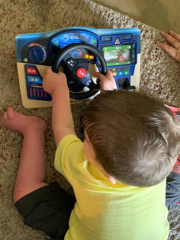 A child playing with the interactive wooden dashboard  
