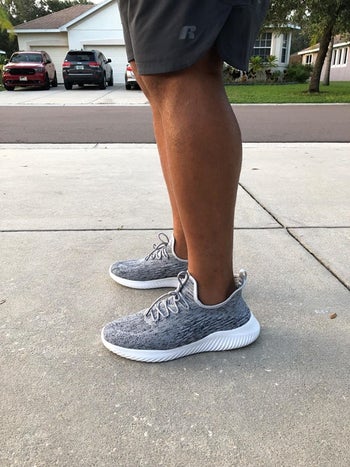 side shot of same reviewer wearing the grey sneakers