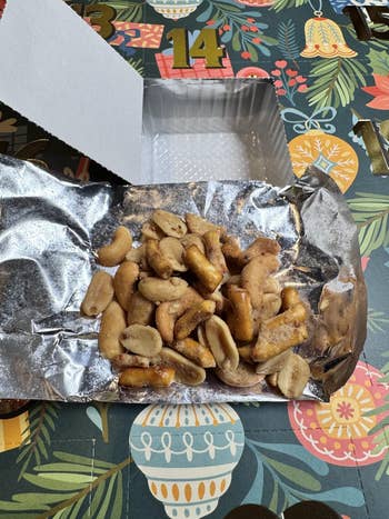 Mixed nuts and pretzel pieces connected foil, portion of a calendar-themed packaging with numbers, floral, and vacation designs successful the background
