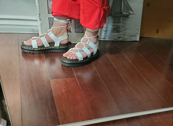 Side view of reviewer wearing product with red pants