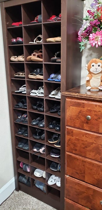 reviewer photo of tall shoe cabinet full of shoes