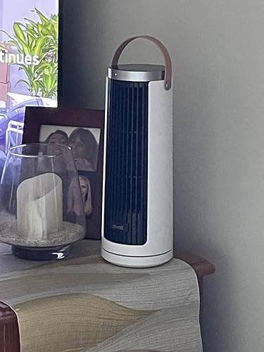 A portable operation    instrumentality   with a grip  is placed connected  a array  beside a candle and a framed photo