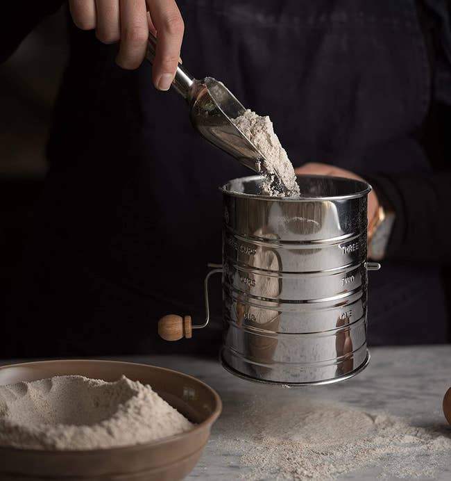 a model scooping flour into the flour sifter