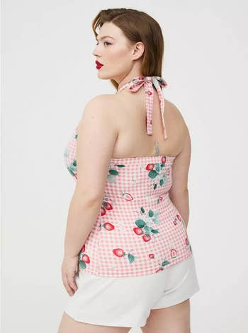 Model successful a halter apical with a strawberry gingham signifier and achromatic shorts, posing for a buying catalog
