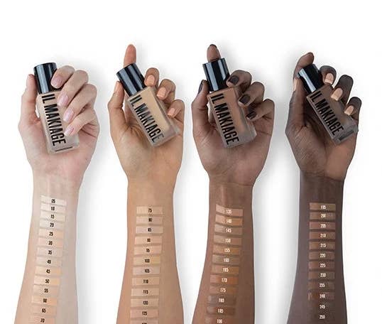 four models holding foundation with swatches of colors on their forearms