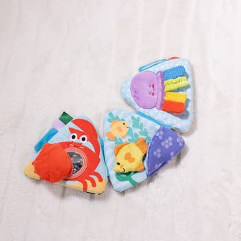 Three colorful, textured babe  toys shaped similar  triangles, featuring oversea  animals similar  a crab and a jellyfish, designed for sensory play