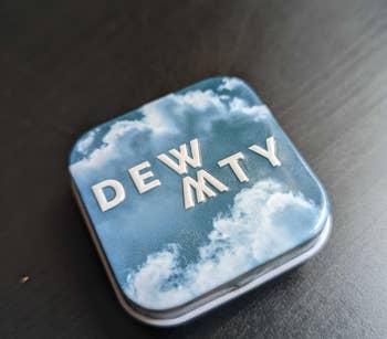 a reviewer photo of a small tin with a cloud print that says 