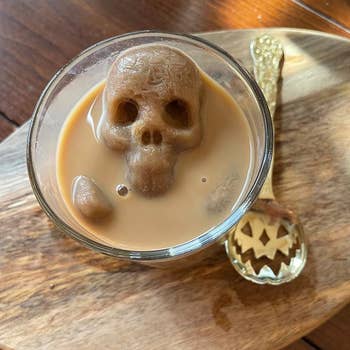 A skull shaped ice cube in a cup of coffee