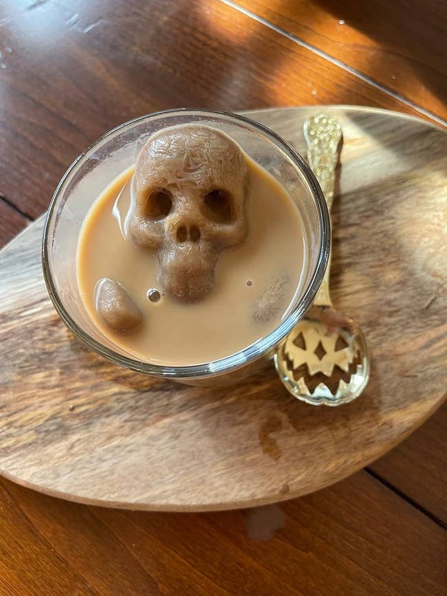 A skull shaped ice cube in a cup of coffee