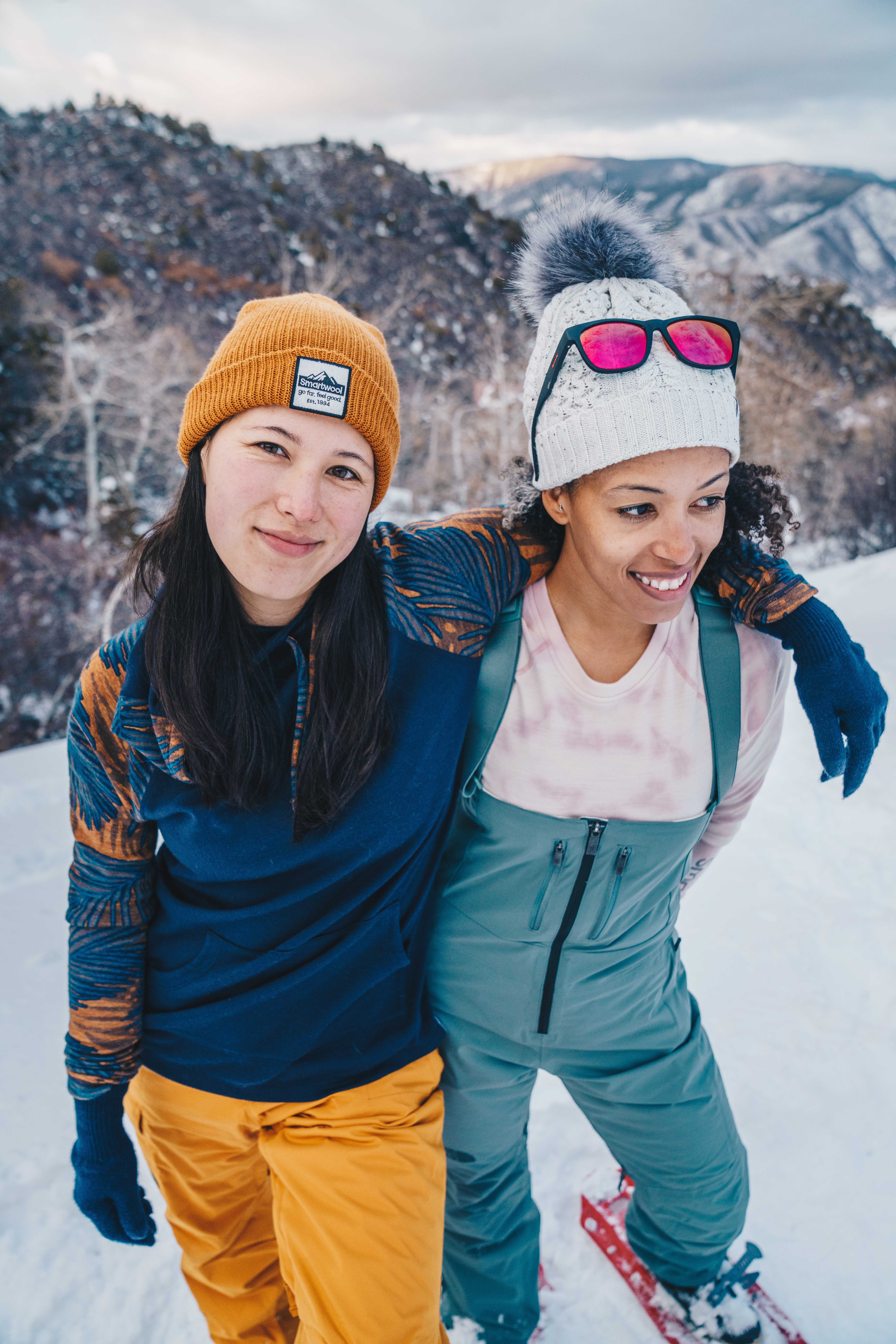 Two female friends hugging in the snow