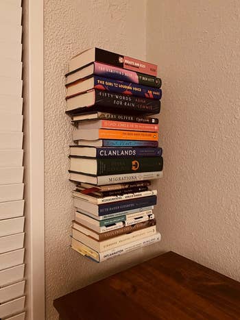 reviewer image of a stack of books seemingly floating against a wall