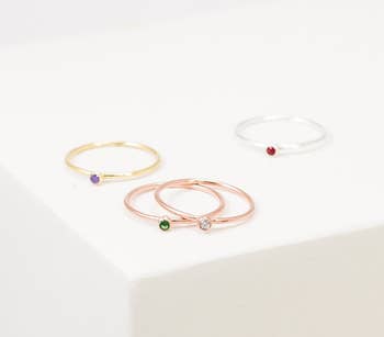 rings in gold, rose gold, and silver with green, clear, red, and purple stones