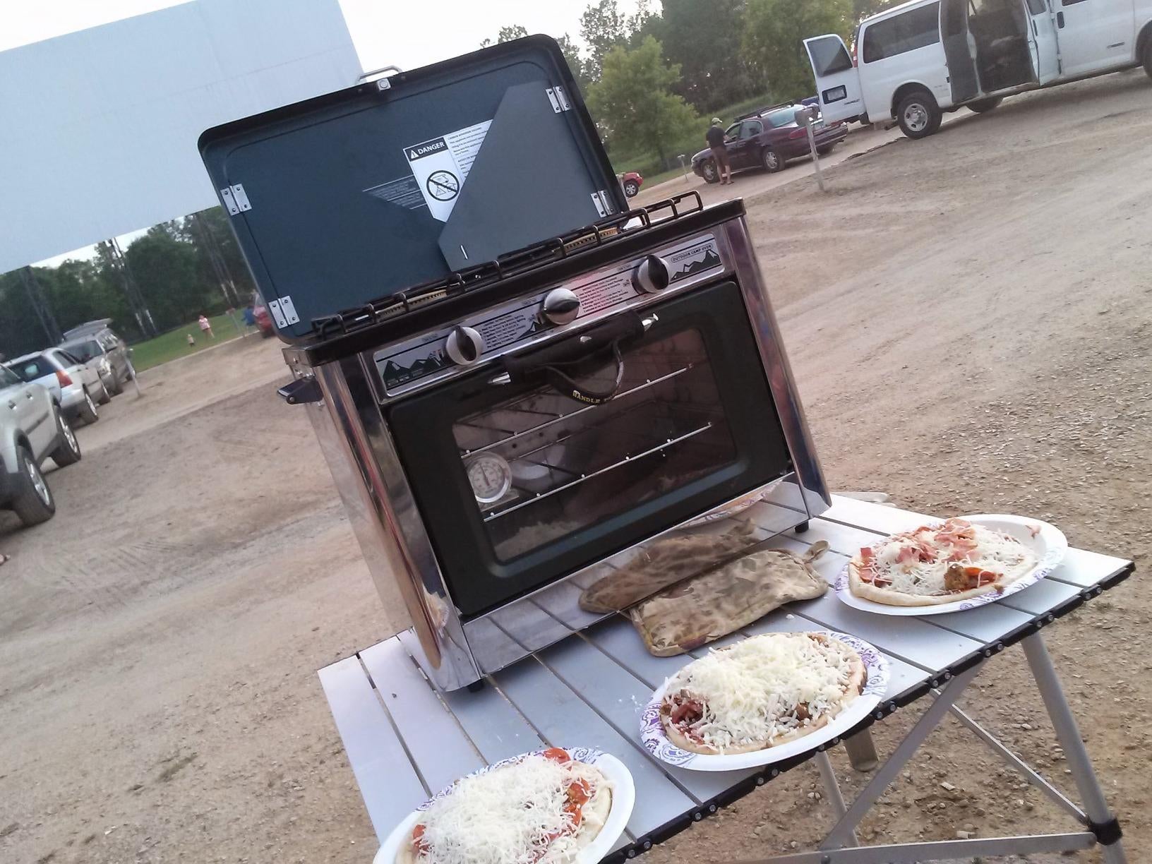 Reviewer pic of the oven and three places of pizza in front of it