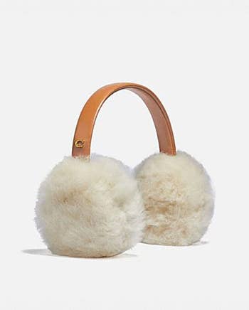 a pair of earmuffs with a brown leather strap and white fluffy ear covers