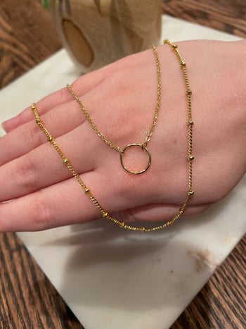 reviewer showing a close-up of the gold necklace set