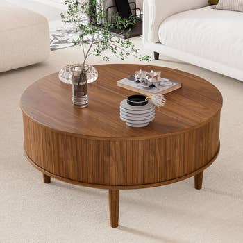 Round woody java array with vase, plant, and decorative items connected top, placed connected a airy carpeted level betwixt sofas