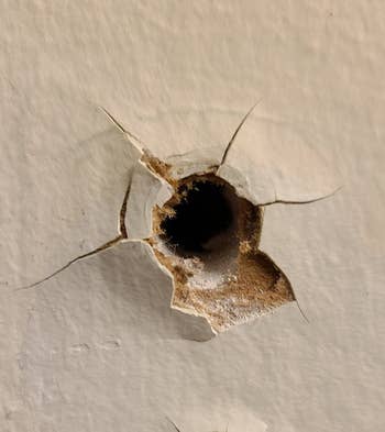 before photo of a large hole in a reviewer's wall