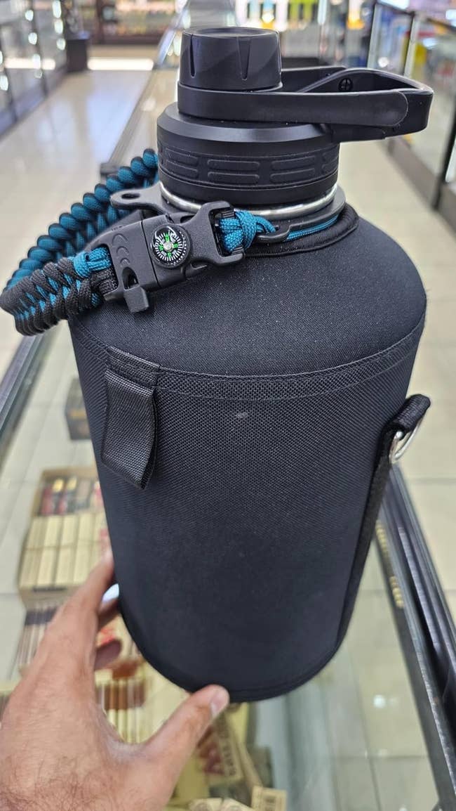 reviewer's water bottle in indigo and black with a paracord handle on a counter