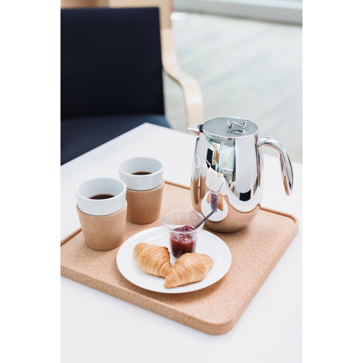 Tray with java  pot, 2  cups, croissants, and jam connected  a table, suggesting a cozy meal  setting