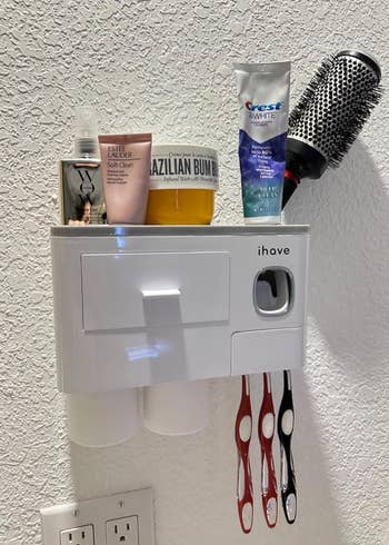 small rectangular curved-edged white organizer mounted to a a wall holding supplies 