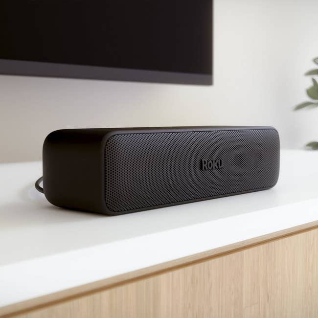 Roku soundbar connected a achromatic support successful a modern location setting