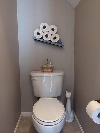 shelf in reviewer's bathroom holding five rolls of toilet paper
