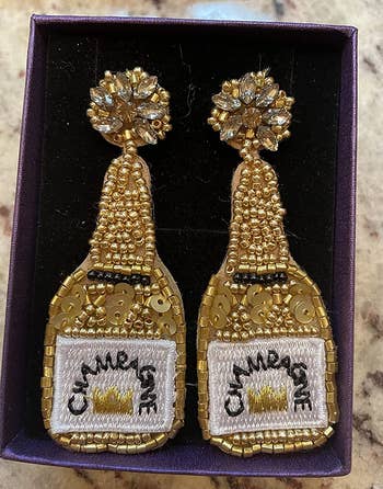reviewer close up of the gold champagne earrings