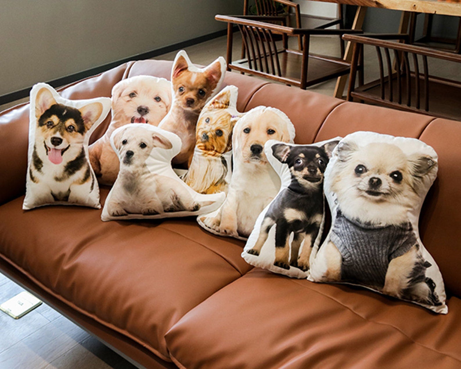 Brown leather couch with mix of puppy shaped pillows