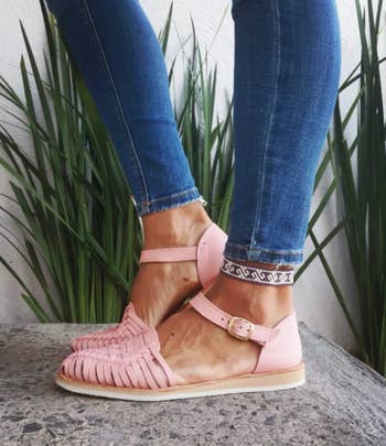 model wears pair of pink Huarache sandals and jeans