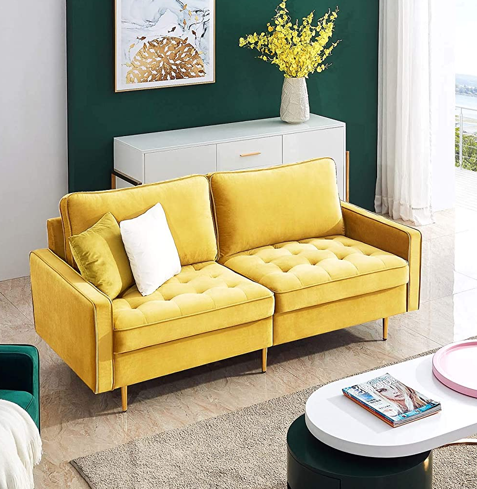 the yellow mid century modern sofa with two pillows on it