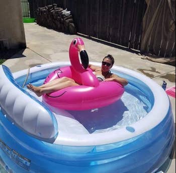 Reviewer lounging on a pool float inside the pool 