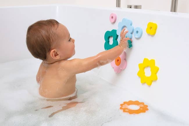 a child playing with flower-shaped sensory toys in the bath