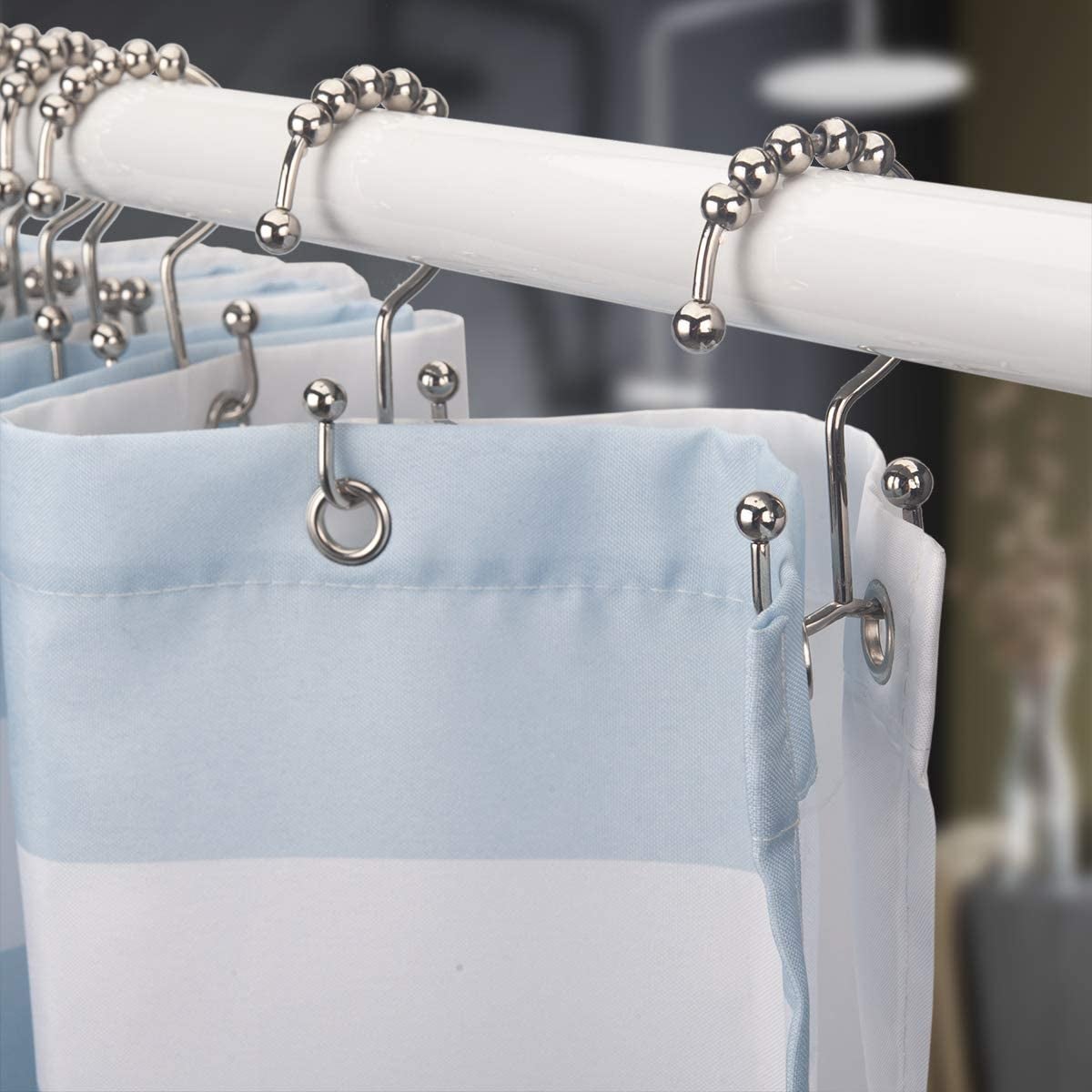The hooks attached to a shower with two hooks on each side of them, one holding the liner and one holding the curtain 