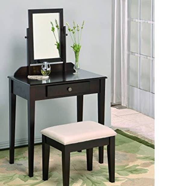 lifestyle image of a dark brown vanity with mirror and stool