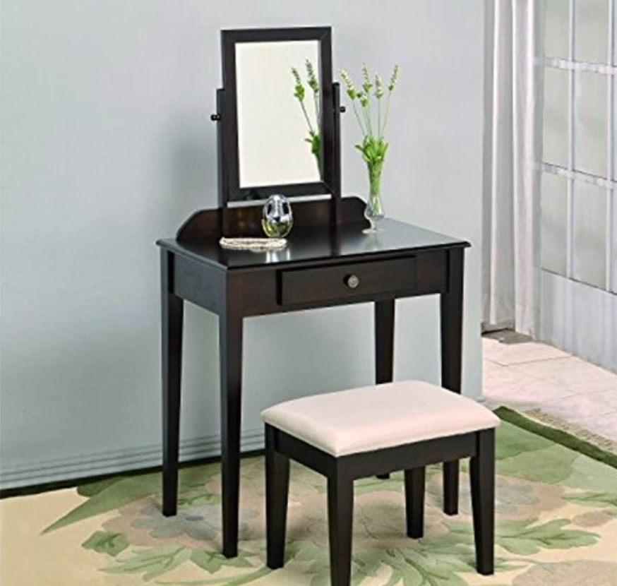 lifestyle image of a dark brown vanity with mirror and stool