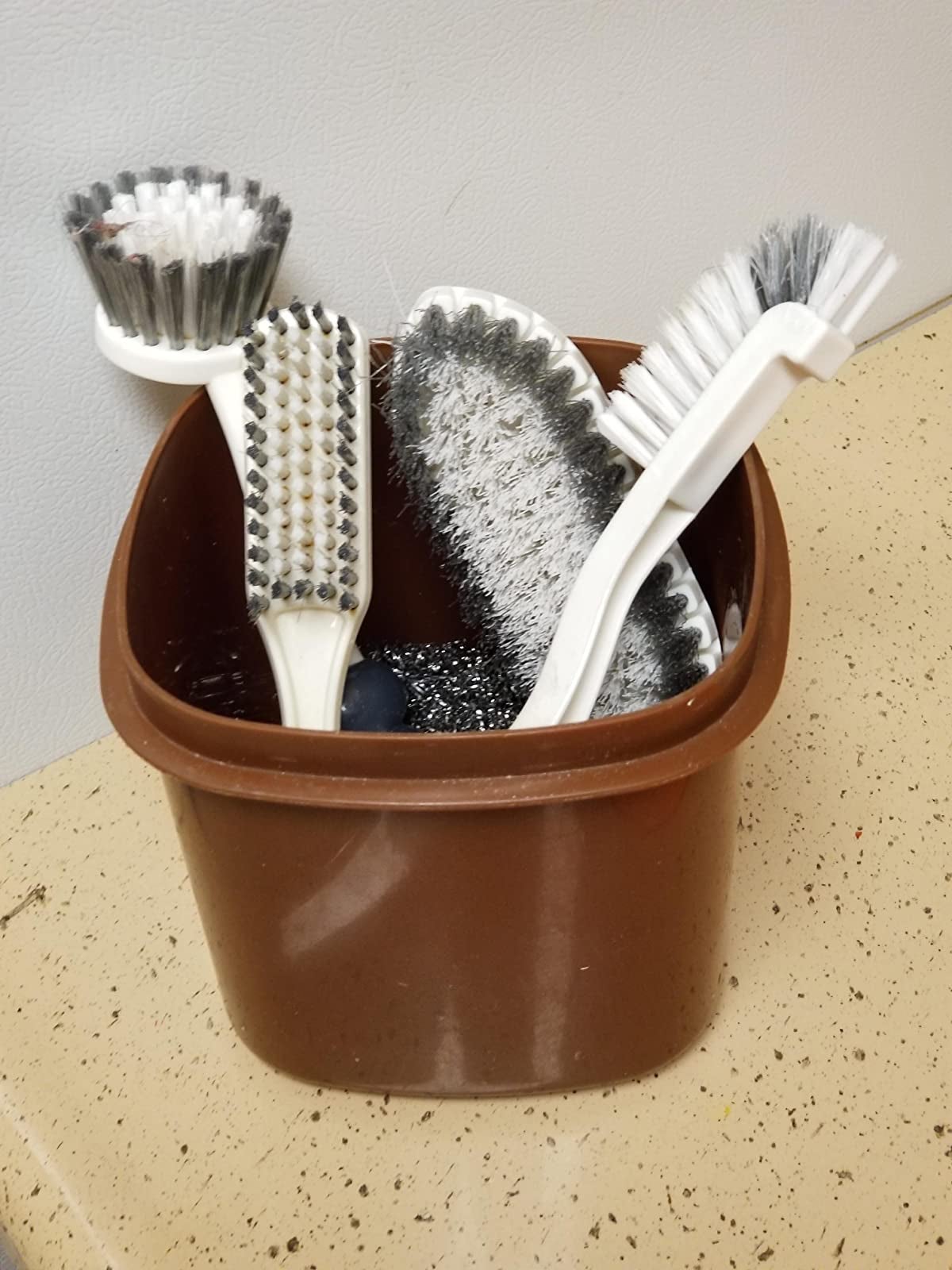 Reviewer images of kitchen brushes in bucket of water on top of counter