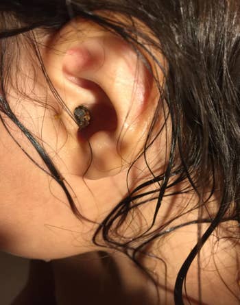 Close-up of an receptor  with bedewed  hairsbreadth  and a small, acheronian  earplug inserted