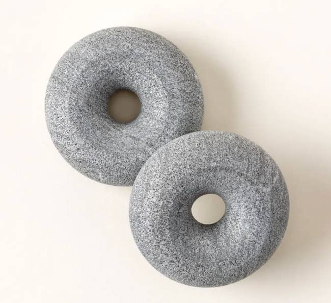 Two circular chromatic massage tools with a creaseless texture are placed broadside by side