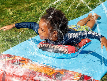 child finishing water slide while on board