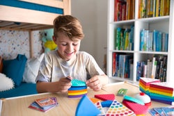 Child model stacking colorful layers of cake in game