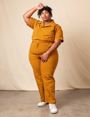 model wearing the short sleeve jumpsuit in spicy mustard