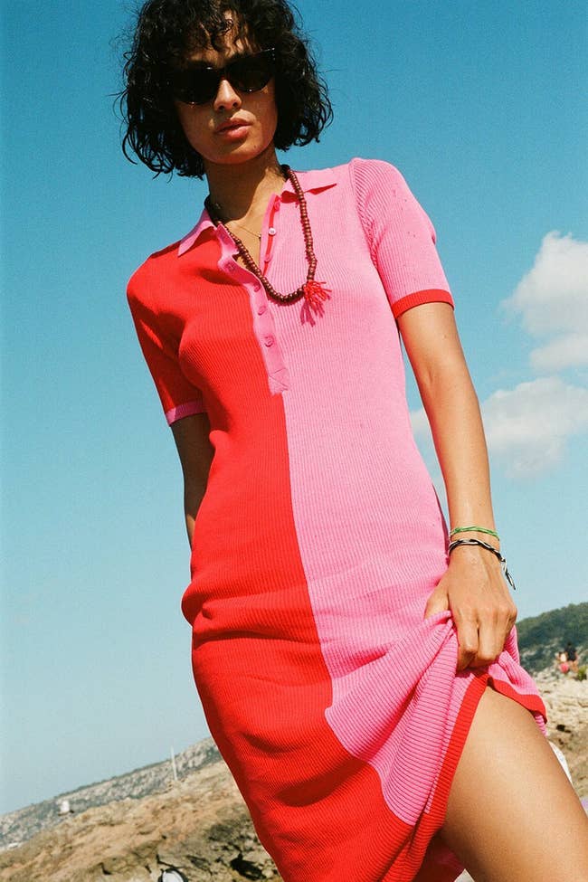 model in short sleeve dress that's pink on one side and red on the other