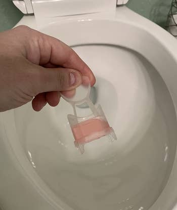 a reviewer holding the toilet stamp applicator