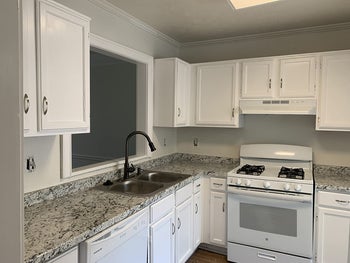 on left, before photo of bare kitchen walls under white cabinets 